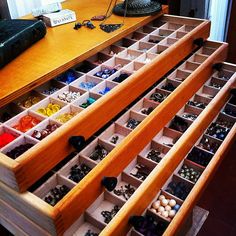 two wooden drawers filled with jewelry on top of a table