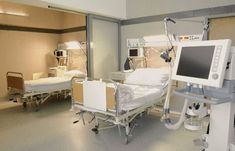 an empty hospital room with multiple monitors and medical equipment