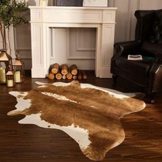 a cowhide rug is on the floor in front of a fire place and fireplace