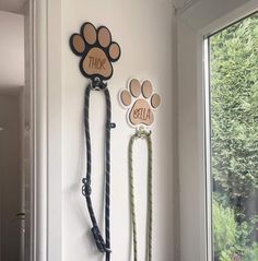 two leashes are hanging on the wall next to a dog's paw sign