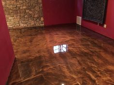 an empty room with red walls and shiny floors