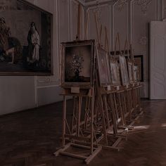 there are many paintings on easels in the room