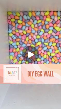 a box filled with lots of different colored candy beans next to a sign that says diy egg wall