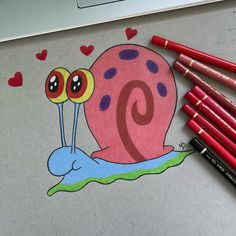 a drawing of a snail with two eyes on it's face and some red crayons next to it