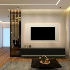 a living room with a large flat screen tv mounted on the wall above a black coffee table