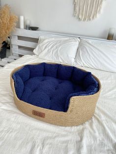 a blue dog bed on top of a white bed