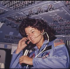 a woman in an airplane cockpit talking on a cell phone