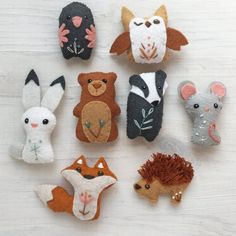 there are many small felt animals on the table together, including one with an animal face