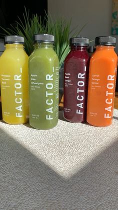 four bottles of juice sitting on top of a table