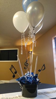 some balloons and music notes are in a bucket