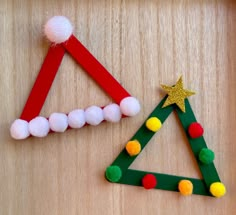 two christmas trees made out of popsicle sticks and pom - poms on a wooden surface