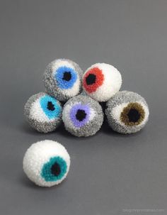 five different colored eyeballs sitting on top of each other in front of a gray background