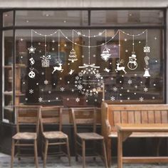 the window is decorated with snowflakes and christmas decorations, including santa's sleighs