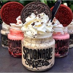 three jars filled with ice cream and oreo cookies on top of a table next to each other