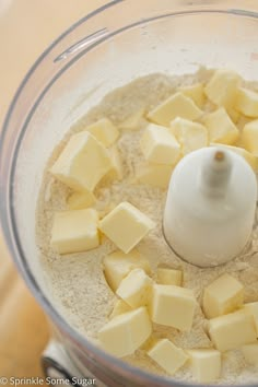 a food processor with cubed cheese in it