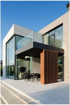 a modern house with glass walls and wooden slats