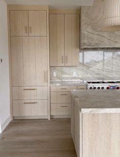 a kitchen with wooden cabinets and marble counter tops