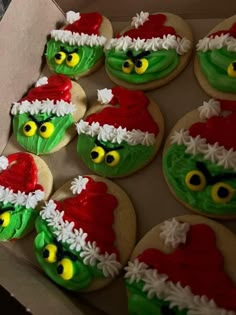 decorated cookies in the shape of grin's faces are displayed on a cardboard box