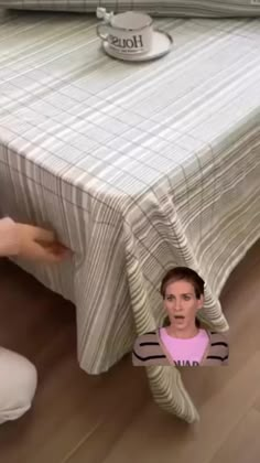 the woman is hiding under the bed sheet