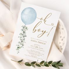 a baby shower with balloons and greenery on the table next to a white plate