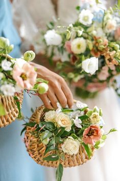 two bridesmaids holding bouquets of flowers in wicker baskets with greenery