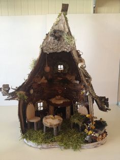 a doll house made out of wood and moss