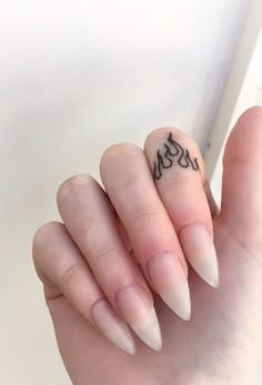 a woman's hand with a small tattoo on the middle finger and an inscription written in black ink