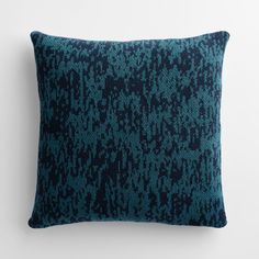 a blue and black pillow on a white wall