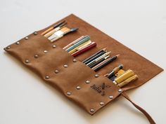 a brown pouch filled with lots of different colored pencils