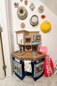 a toy kitchen set up in the corner of a room