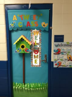 a door decorated with a birdhouse and welcome home sign on the front entrance to a classroom