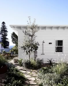 a white house with trees and plants around it