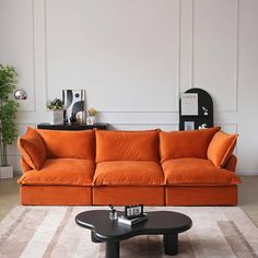 an orange couch sitting on top of a white rug