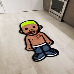 a cartoon character rug on the floor in a kitchen with an oven and microwave behind it