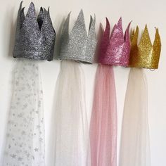 four princess crowns are lined up against the wall