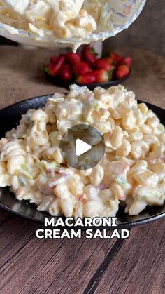 macaroni and cheese salad on a black plate with strawberries in the background