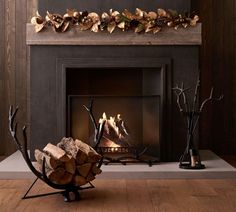 a fire place with logs in front of it and an arrangement of branches on the mantle