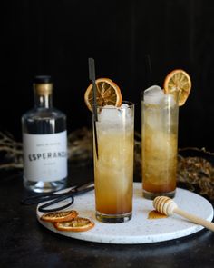 two glasses filled with drinks sitting on top of a white plate