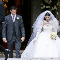 the bride and groom are walking together outside