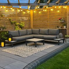 an outdoor living area with patio furniture and string lights on the pergolated roof