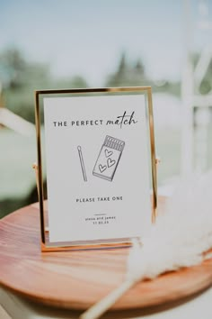 the perfect match please take one sign is displayed on a wooden table with white feathers