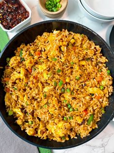 a pan filled with rice and vegetables on top of a table