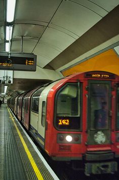 a red train is pulling into the station