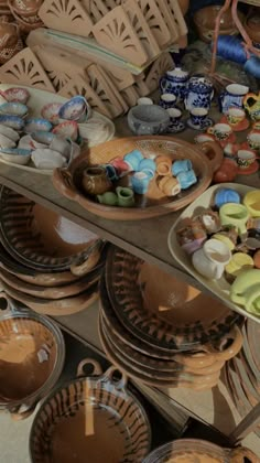 there are many bowls and plates on the table together in this display case, including one that has been made from clay