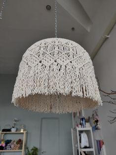 a white chandelier hanging from the ceiling in a room with bookshelves