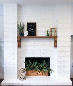 a white brick fireplace with potted plants on top