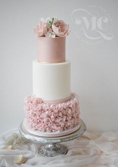 a three tiered cake with pink flowers on top