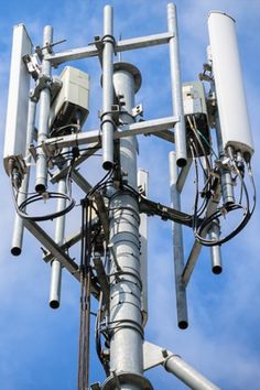 the top of a cell phone tower with multiple cellular antennas and wires attached to it