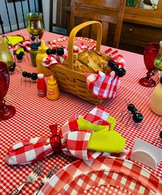 a red and white checkered table cloth with wine glasses, bread in a basket on it