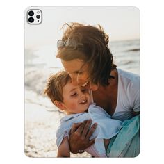 a woman holding a child on the beach